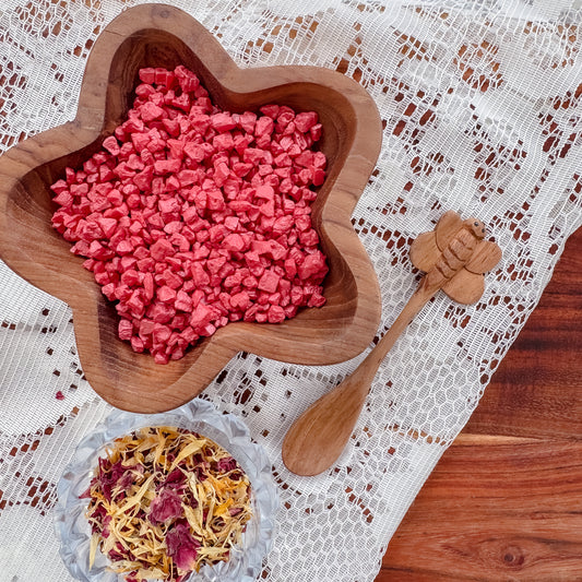 Wooden sensory table with red fizz rocks, dried flowers and wooden tools, for child development and emotional regulation.