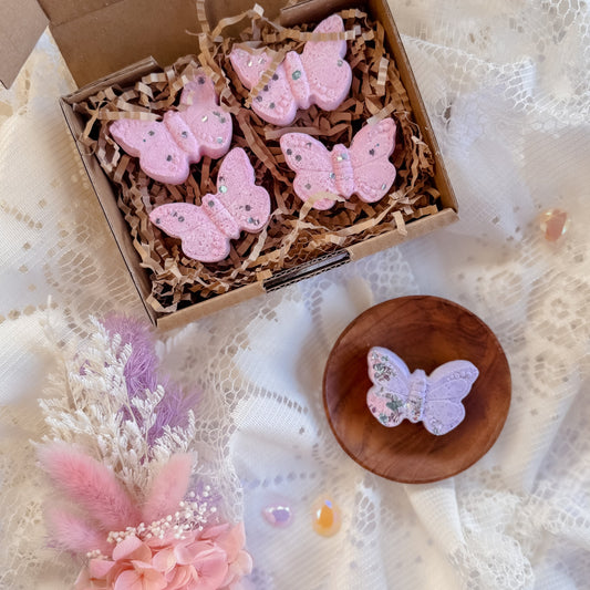 Pink butterfly-shaped fizzer for children sensory play, available in a box on a lace background