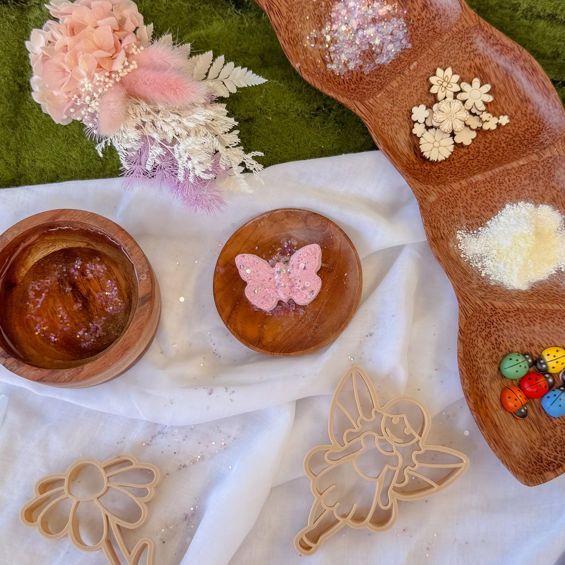 Sensory play set up with decorative wooden tool with floral designs, fizzy potion mix and butterfly shaped fizzer. Fairy themed. Sensory play