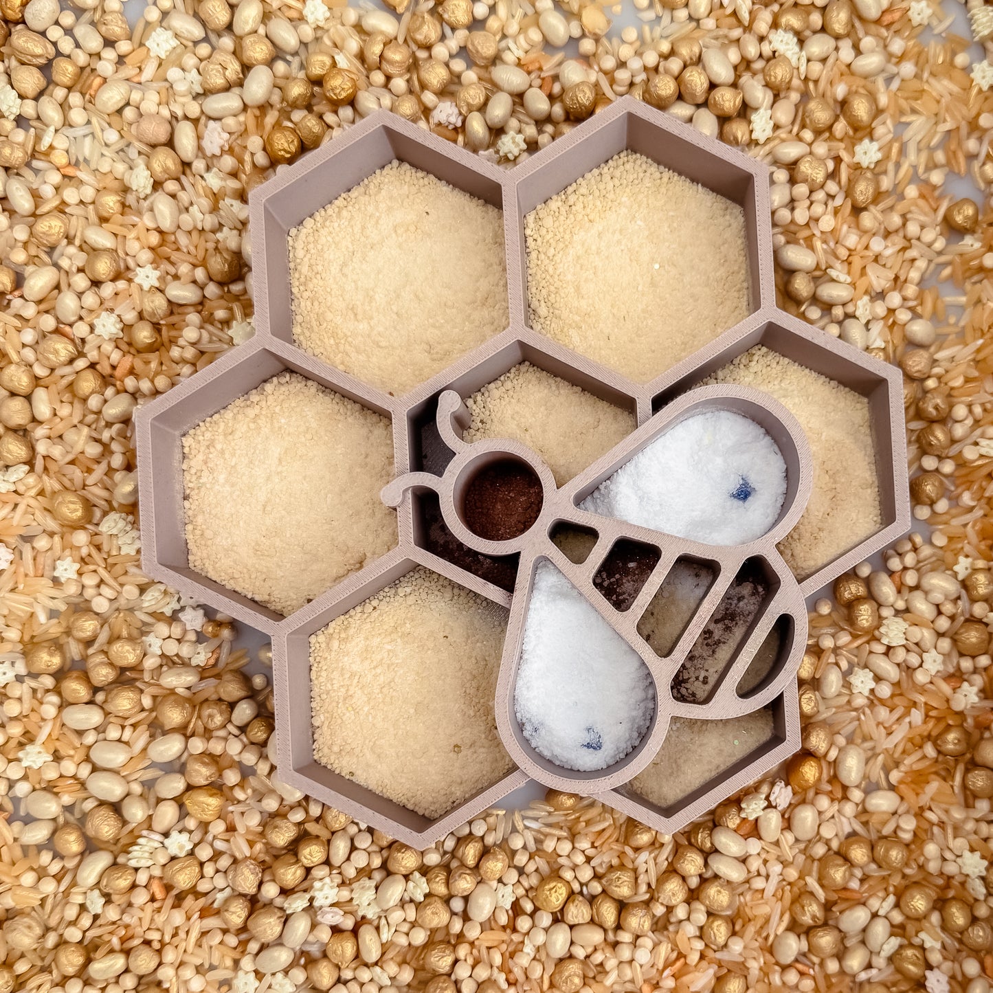 Honeycomb-shaped sensory tray with bee, wood spoon and golden sensory base and fizz 