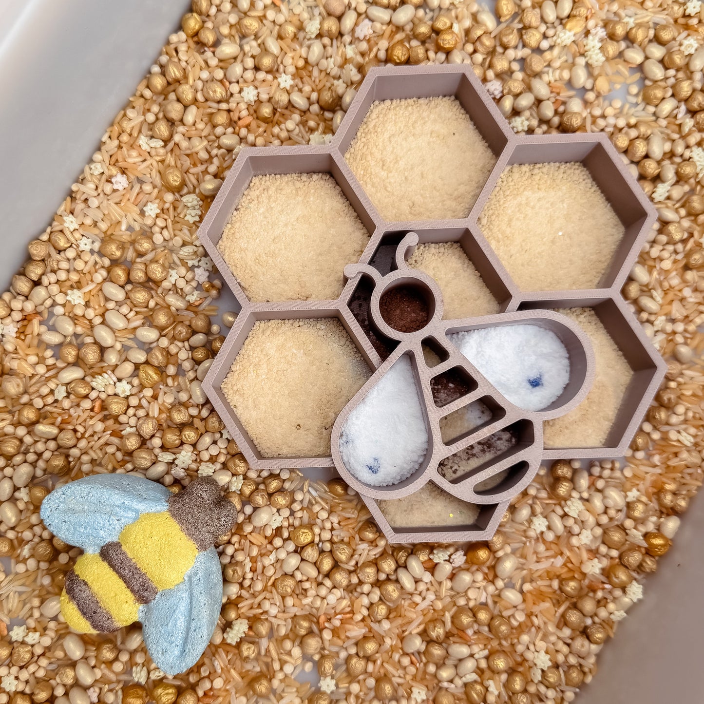 Honeycomb-shaped sensory tray with bee, wood spoon and golden sensory base and fizz 