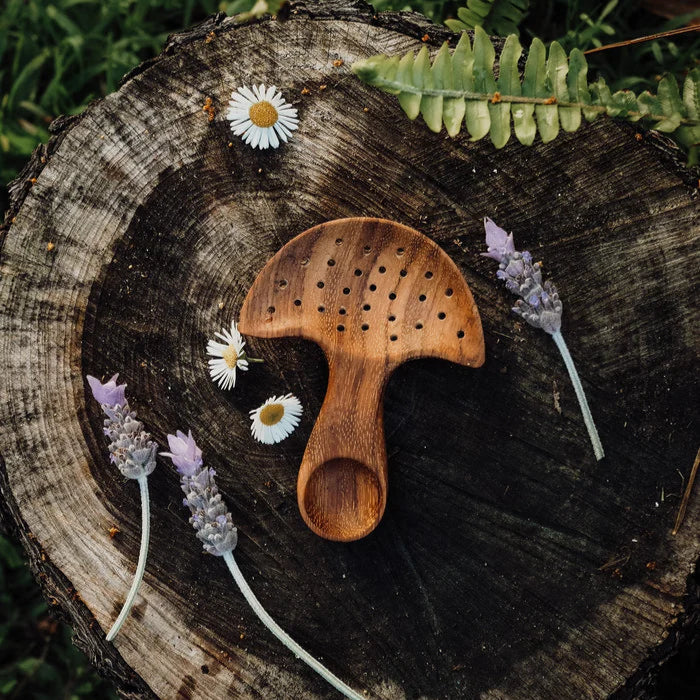 Wooden comb on a tree stump with flowers and leaves
