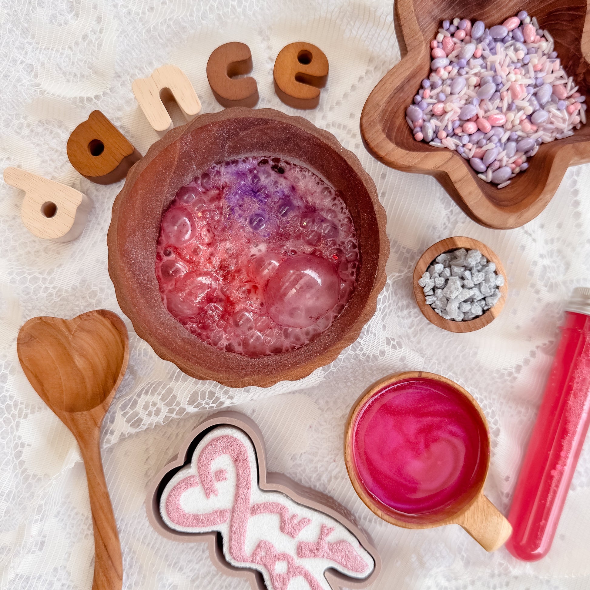 Ballerina themed sensory play for kids, silver shimmer rocks, pink potion, fizz purple and white sensory bin base, wooden heart spoon, bubble and star bowl. Ballet dance activity. 