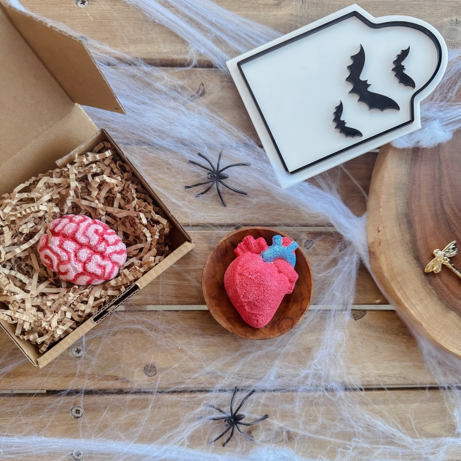 Halloween-themed decorations on a wooden surface with spider webs and spiders.